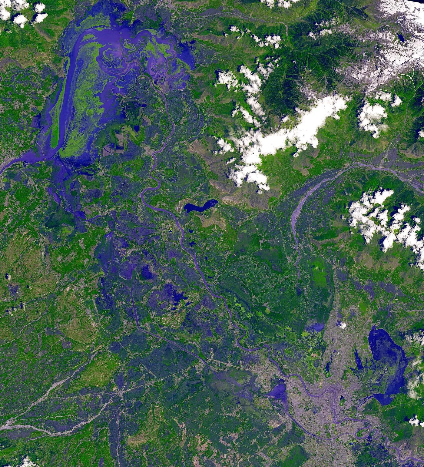 A false-colour satellite image of Dal Lake and Srinagar, in which vegetation appears in blues and purples and the built-up city appears in pale grey.