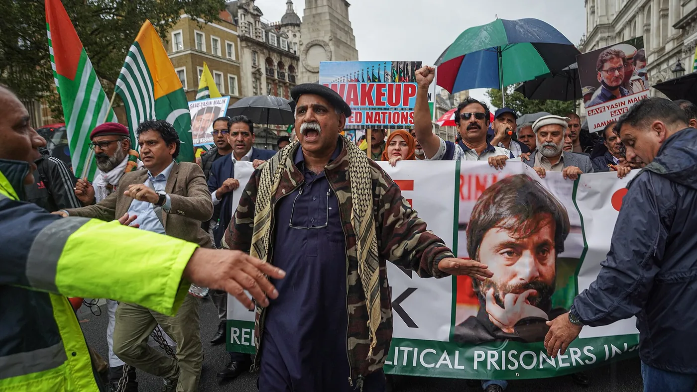 A photograph of a crowd of protesters in central London holding placards and flags, demanding an end to human rights violations in Kashmir.