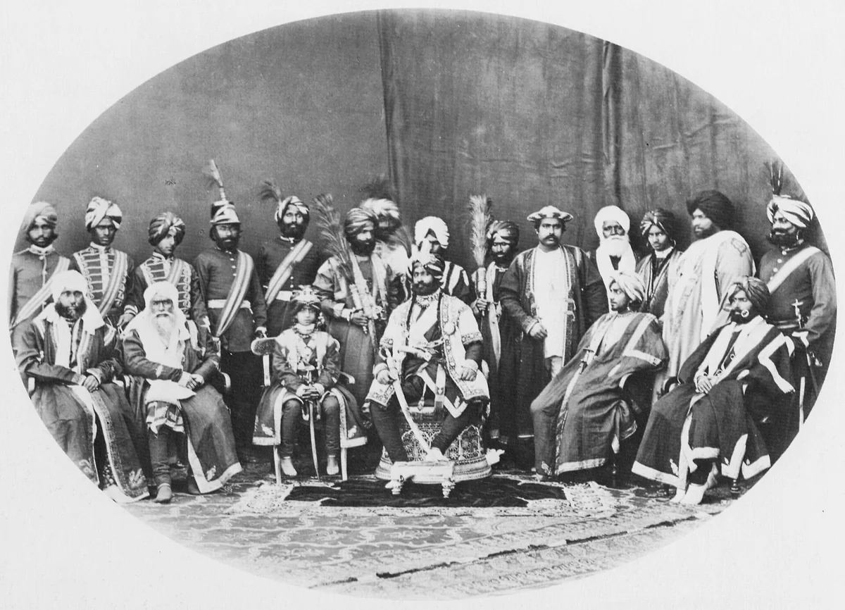 A 19th-century photograph by Samuel Bourne of the Maharaja of Kashmir seated with his retinue, arranged in an oval frame.
